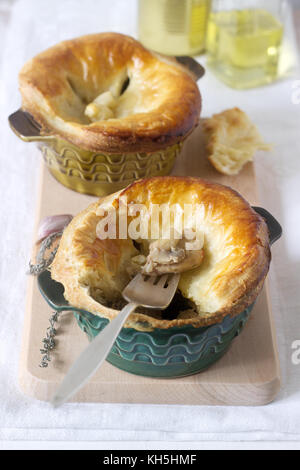 Chicken pie with mushrooms, cooked in individual ceramic forms. Rustic style, selective focus. Stock Photo