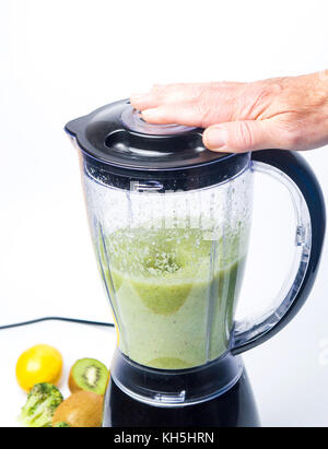 https://l450v.alamy.com/450v/kh5hrn/man-making-a-green-smoothie-drink-in-a-blender-isolated-kh5hrn.jpg