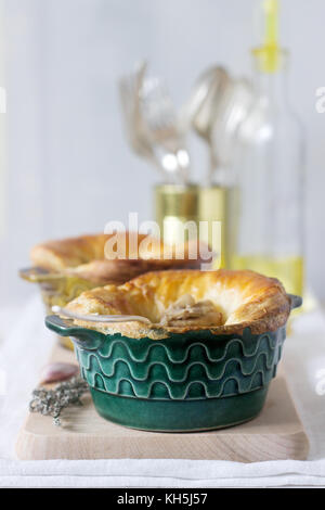 Chicken pie with mushrooms, cooked in individual ceramic forms. Rustic style, selective focus. Stock Photo