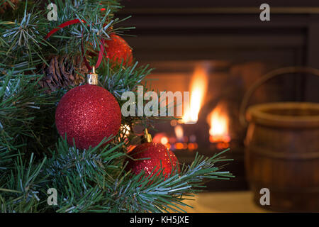 Red Christmas Ball on a tree with fireplace in background Stock Photo