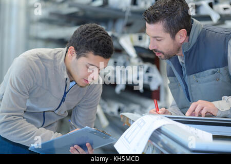 engineer taking notes from manager at control room Stock Photo