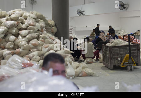 Gaza City, The Gaza Strip, Palestine. 14th Nov, 2017. Palestinians receive monthly food aid at a United Nations distribution center in the Jabalia refugee camp in the northern Gaza Strip. Credit: ZUMA Press, Inc./Alamy Live News Stock Photo