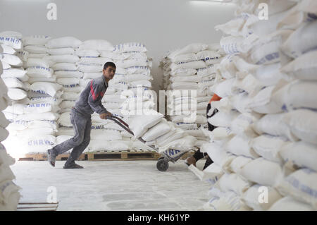 Gaza City, The Gaza Strip, Palestine. 14th Nov, 2017. Palestinians receive monthly food aid at a United Nations distribution center in the Jabalia refugee camp in the northern Gaza Strip. Credit: ZUMA Press, Inc./Alamy Live News Stock Photo