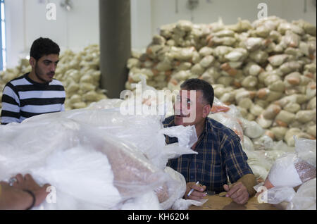 Gaza City, The Gaza Strip, Palestine. 14th Nov, 2017. Palestinians receive monthly food aid at a United Nations distribution center in the Jabalia refugee camp in the northern Gaza Strip. Credit: ZUMA Press, Inc./Alamy Live News Stock Photo