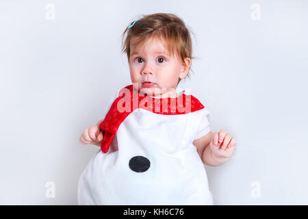 Amazed attractive baby girl in Christmas costume having fun . Close-up portrait little girl in snowman costume Stock Photo