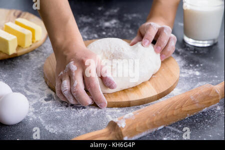 Making dough by female hands on wooden table background Stock Photo