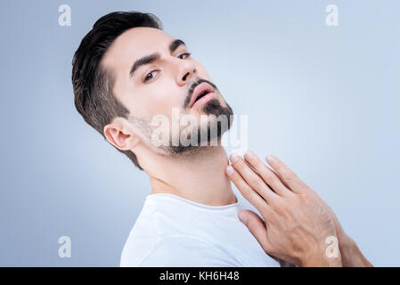 Emotional young man leaning back while looking straight Stock Photo