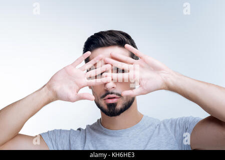 Shy young person hiding his face from unknown people Stock Photo