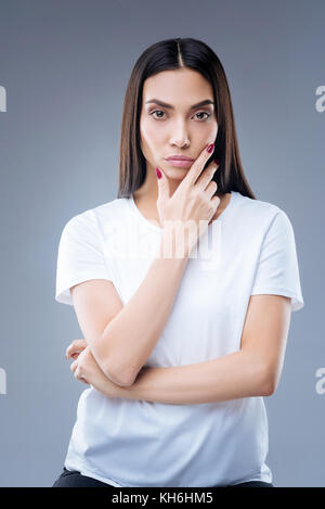 Beautiful thoughtful woman looking at her own reflection in a mirror Stock Photo