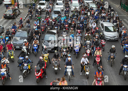 A lot of scooters and cars waiting at traffic lights on the Ratchadamri Road in Bangkok, Thailand, viewed from above. Stock Photo