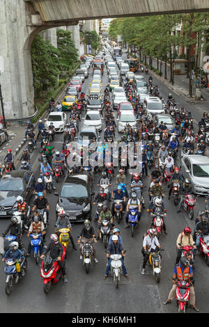 A lot of scooters and cars waiting at traffic lights on the Ratchadamri Road in Bangkok, Thailand, viewed from above. Stock Photo