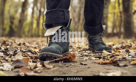 Men's shoes in autumn leaves. A man walking in a park full of autumn leaves Stock Photo
