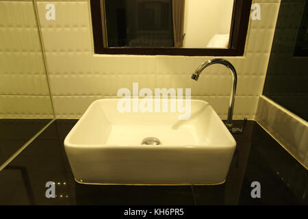 ceramic washbasin and metal faucet in bathroom Stock Photo