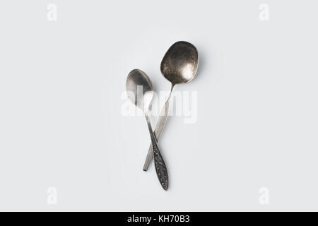 crossed spoons on white table Stock Photo