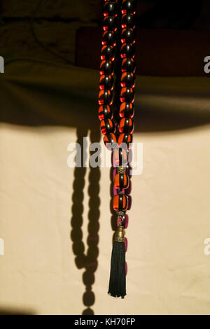 Red and black amber Worry beads or komboloi, kompoloi a string of beads manipulated with one or two hands and used to pass time in Greek and Cypriot c Stock Photo