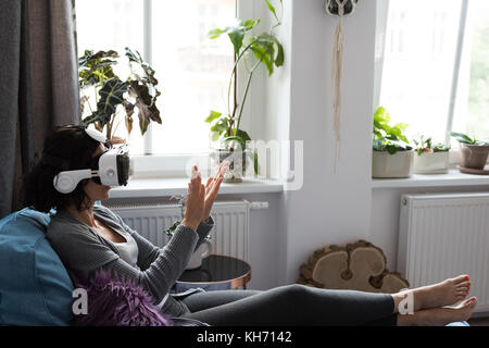 Woman using virtual reality headset at home Stock Photo