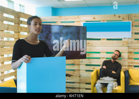 Confident female executive giving presentation in office Stock Photo