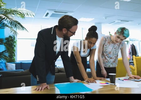 Executives discussing over documents in boardroom Stock Photo
