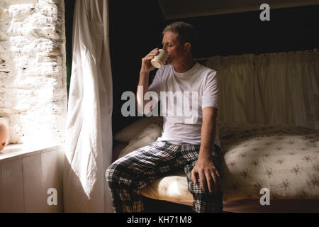 Senior man having coffee in bedroom at home Stock Photo