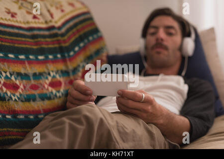 Man in headphones using mobile phone at home Stock Photo