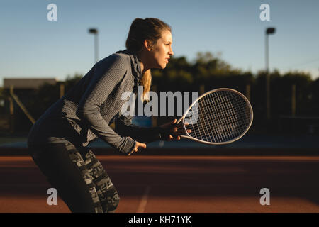 Determined tennis player practicing tennis on sunny day Stock Photo
