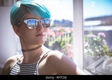 Stylish woman in sunglasses posing at home Stock Photo