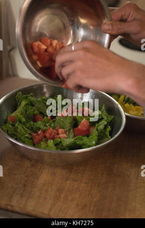 Mid section of man preparing salad in kitchen Stock Photo