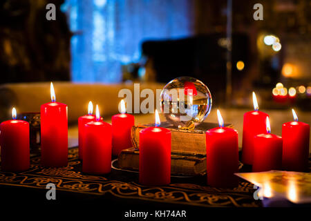 Crystal ball to prophesy or esoteric clairvoyance during a Seance in the candle light Stock Photo