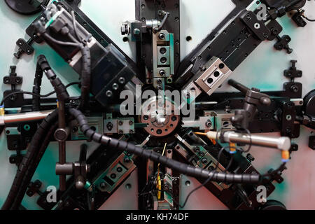 Industrial automatic spring coiling machine. Selective focus. Stock Photo