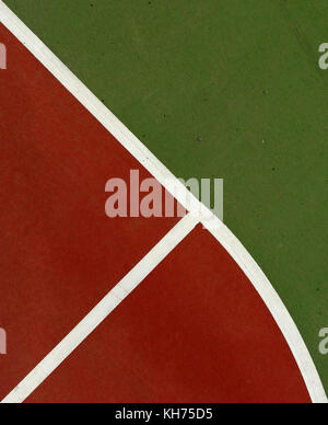 Pole aerial image of an outdoor basketball court. Includes red key, white lines, green surface and triangular shapes. Stock Photo