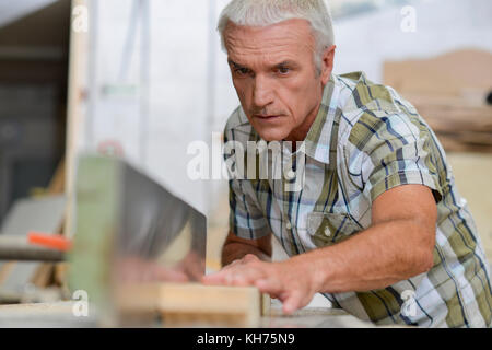 Carpenter using a table top saw Stock Photo