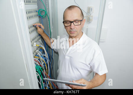 technician using tablet in server room at the data centre Stock Photo