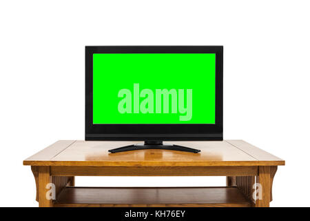 Flat screen television on wood table isolated on white with chroma key green screen insert. Stock Photo