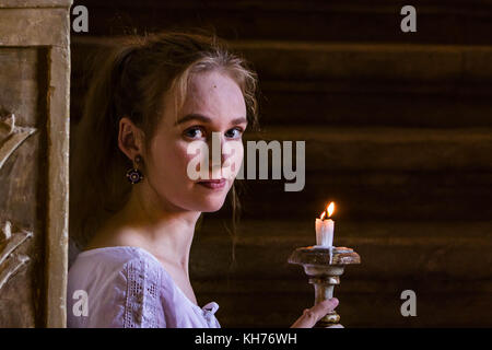 Woman with candle on stairs Stock Photo
