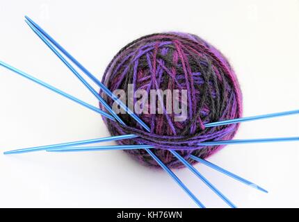 A variegated ball of knitting yarn with needles Stock Photo