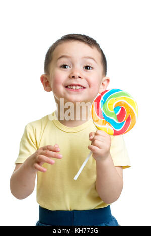 Happy child boy eating big candy lollipop isolated on white background Stock Photo