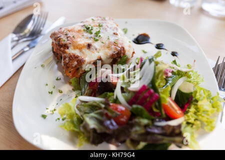 Authentic Italian Meat Lasagna with fresh salad. Stock Photo