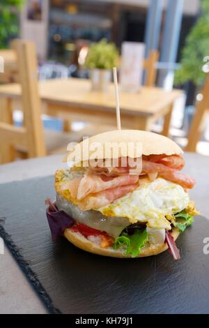 Burger with fried egg and bacon. Stock Photo