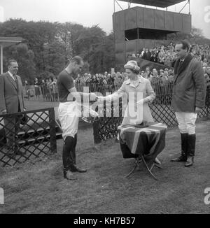 12/05/1963. Queen Elizabeth II presents the Royal Windsor Horse Show Cup to the Duke of Edinburgh who, as captain of Windsor Park, had helped defeat Bucket Hill in the final on Smith's Lawn, Windsor Great Park. The Royal couple will celebrate their platinum wedding anniversary on November 20. Stock Photo