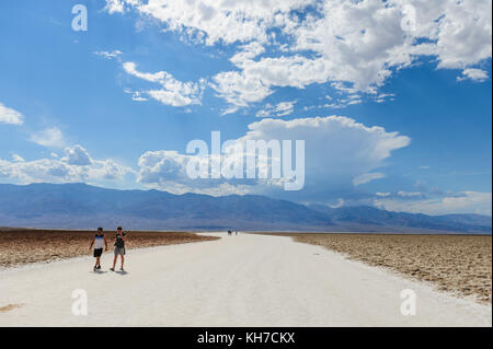 Tourists walking on a salt flats of Badwater Stock Photo