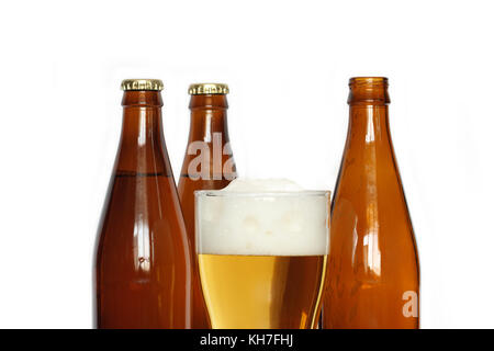 Closeup of beer glass near three bottles isolated on white background Stock Photo