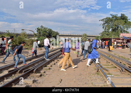 Dhaka, Bangladesh. 14th Nov, 2017. DHAKA, BANGLADESH - NOVEMBER 16, 2017: Pedestrians crossing the railway tracks at Dhaka when the approaching train is just seconds away from the level crossing, Dhaka, Bangladesh. The authorities have taken numerous steps to raise awareness about crossing streets and railway level crossings safely in Dhaka, but pedestrians continue to violate rules and put their lives at risk. Credit: SK Hasan Ali/Alamy Live News Stock Photo