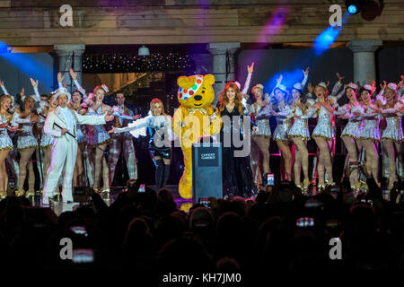 Covent Garden, London, UK, 14th Nov 2017. The Covent Garden Christmas lights 2017 are switched on by Pudsey with special guests, singer Kylie Minogue and designer Charlotte Tilbury. Festive celebrations include performances from the acclaimed hit West End musical 42nd Street performing numbers from the show. Pudsey and his special guests Kylie switch on the lights in collaboration with BBC Children in Need this year. The Piazza hosts London’s biggest hand-picked Christmas tree. Credit: Imageplotter News and Sports/Alamy Live News Stock Photo