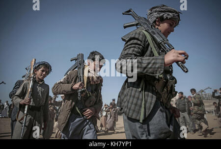 Sanaa, Yemen. 16th Nov, 2017. Boys shoulder weapons as Houthi rebel fighters hold a gathering aimed at mobilizing more fighters before heading to battlefronts in Sanaa, Yemen, 16 November 2017. According to the international aid group Save the Children the ongoing war in the country takes a particular heavy toll on the youngest, with approximately 120 children dying every day. The group says already over 50,000 children are believed to have died in 2017. Credit: Hani Al-Ansi/dpa/Alamy Live News Stock Photo