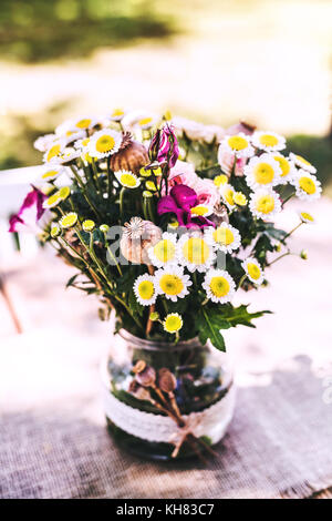 Flowers in the vase on the table in the garden. Stock Photo