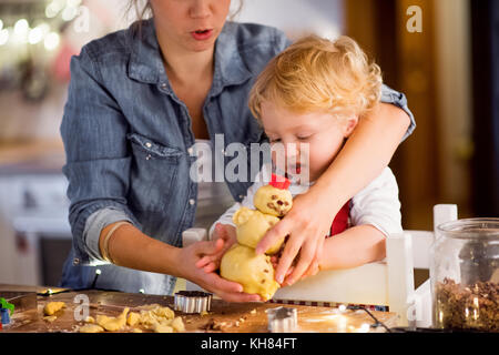 Young family making cookies at home. Stock Photo