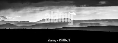 Monochrome sunset over mountains. Fantastic panorama view of misty layered icelandic landscape with dramatic clouds. Iceland. Stock Photo