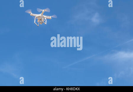 White drone, quadrocopter with video camera on the ground. Device used for filming Stock Photo