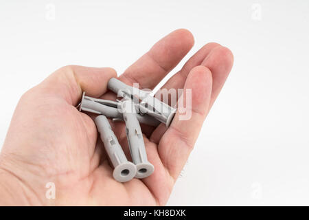 Some plastic wall plugs on the hand Stock Photo