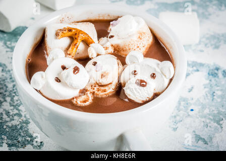 Idea for a children's Christmas snack, hot chocolate with teddy bears and deer marshmallow. On a light blue background, copy space Stock Photo